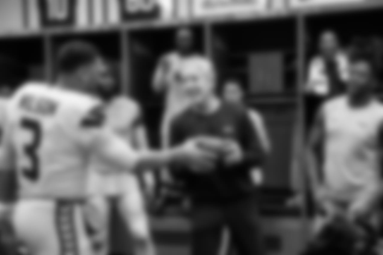 Quarterback and offensive captain Russell Wilson gives the game ball to head coach Pete Carroll who became the franchise all-time winningest coach with the victory.