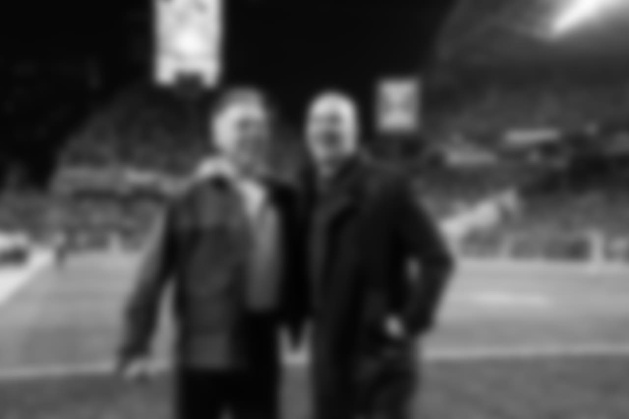 Seahawks legends Jim Zorn and Matt Hasselbeck share a laugh on the field as they are introduced to the crowd during a third quarter break.
