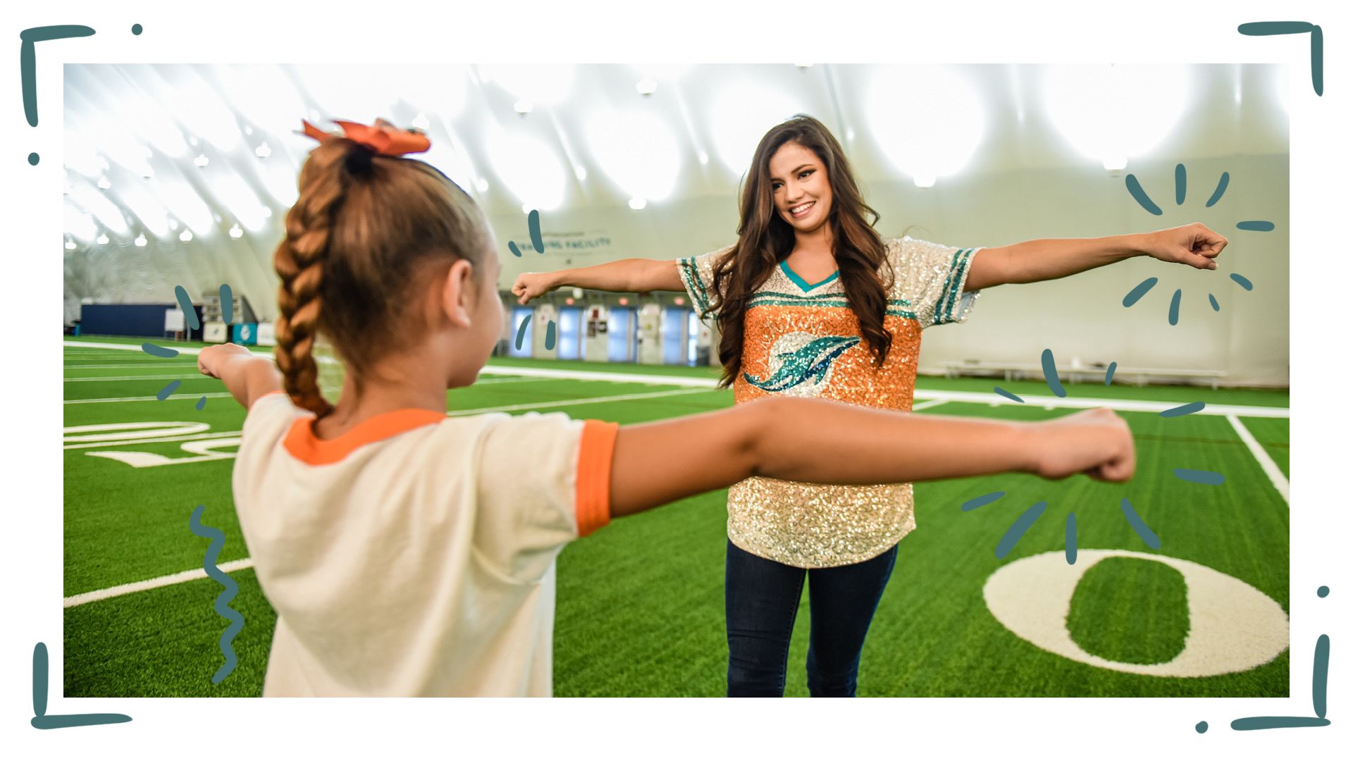 Image: Dolphins Cheerleader Instructing Junior Cheerleader