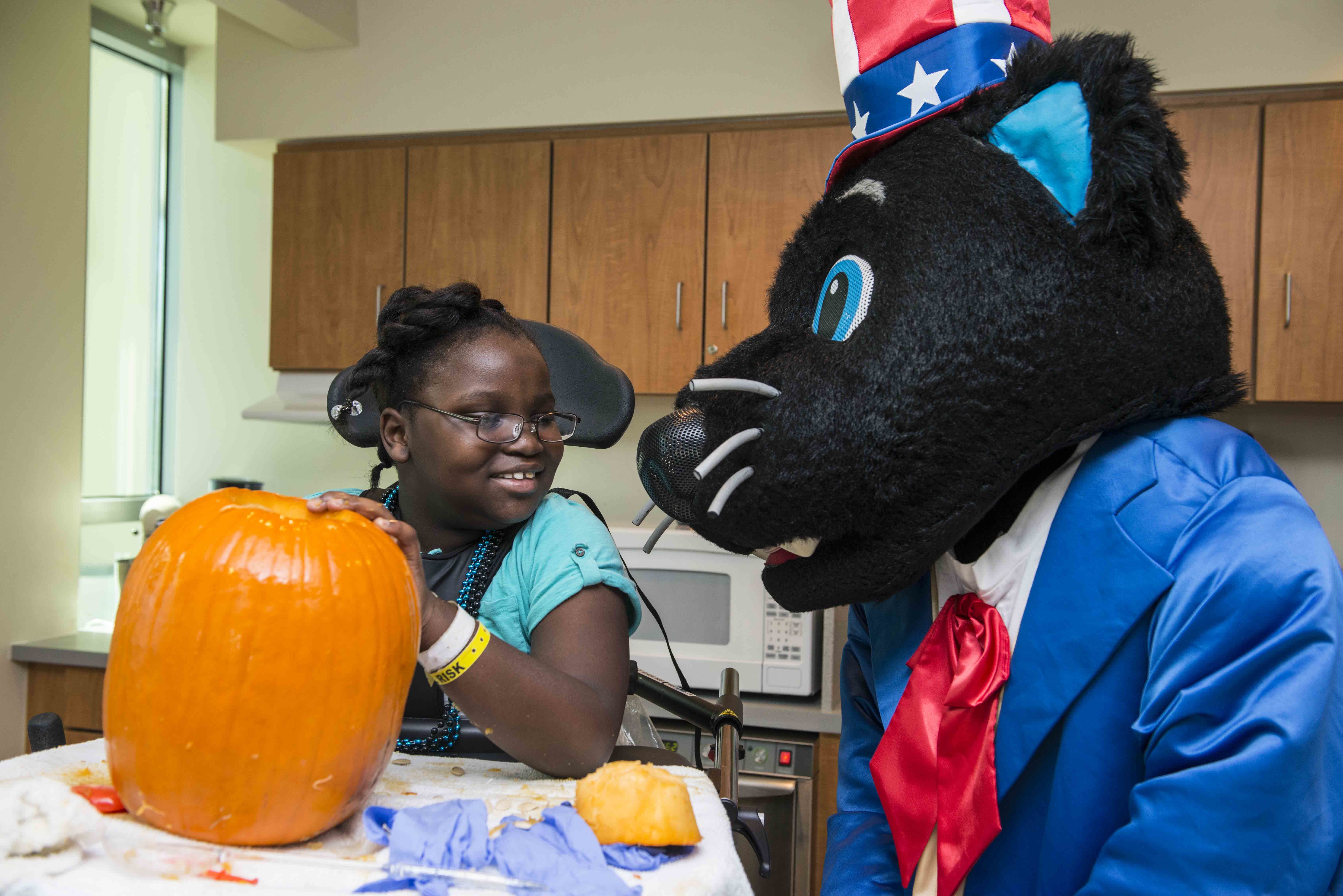 Sir Purr, the Carolina Panthers' mascot leads the Harris YMCA flag