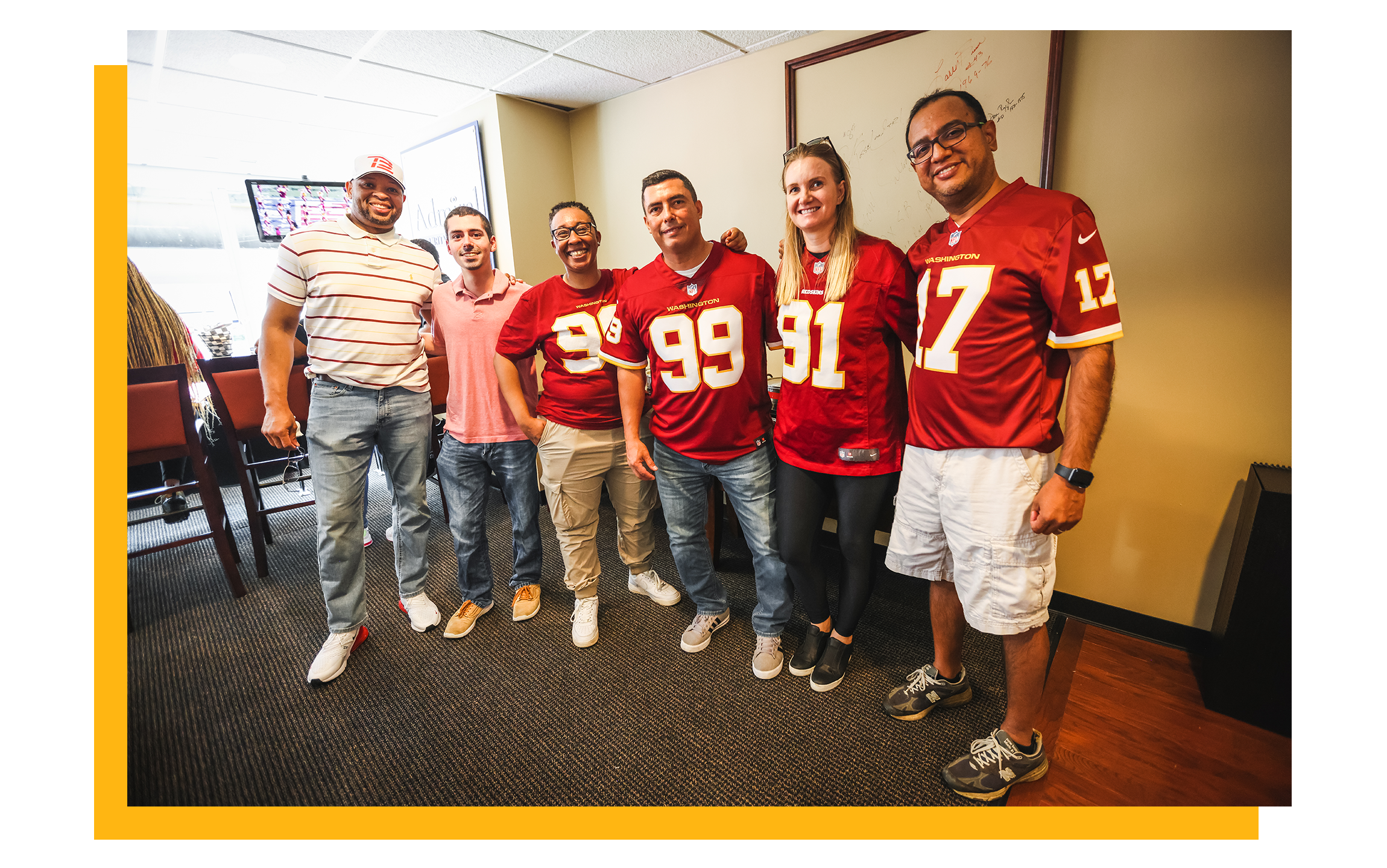 Photo of six fans in team jerseys posing for a photo inside an Executive Suite.