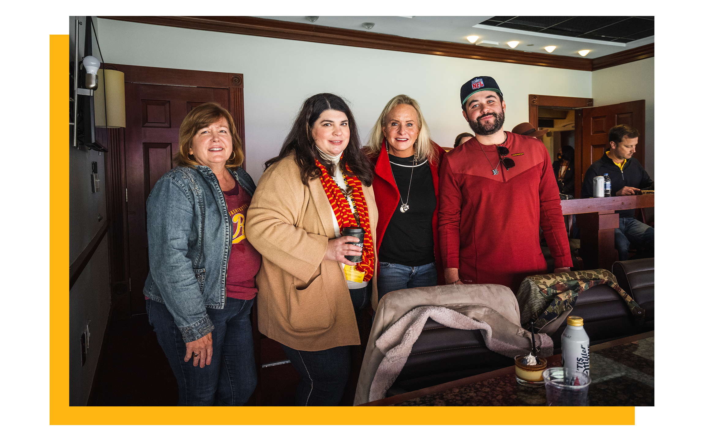 Photo of four fans standing in an Owner's Club Suite.