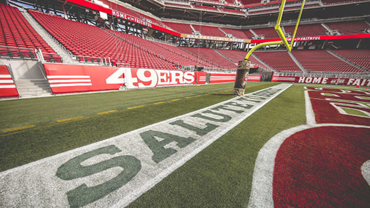 Service members from all five branches of the armed services carry a large  American flag out onto the field at the Salute to Service Chicago Bears  game Nov. 27 at Soldier Field