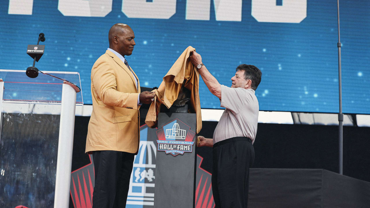 Former NFL player Bryant Young, right, poses with his bust and presenter  Edward DeBartolo Jr., during an induction ceremony at the Pro Football Hall  of Fame in Canton, Ohio, Saturday, Aug. 6