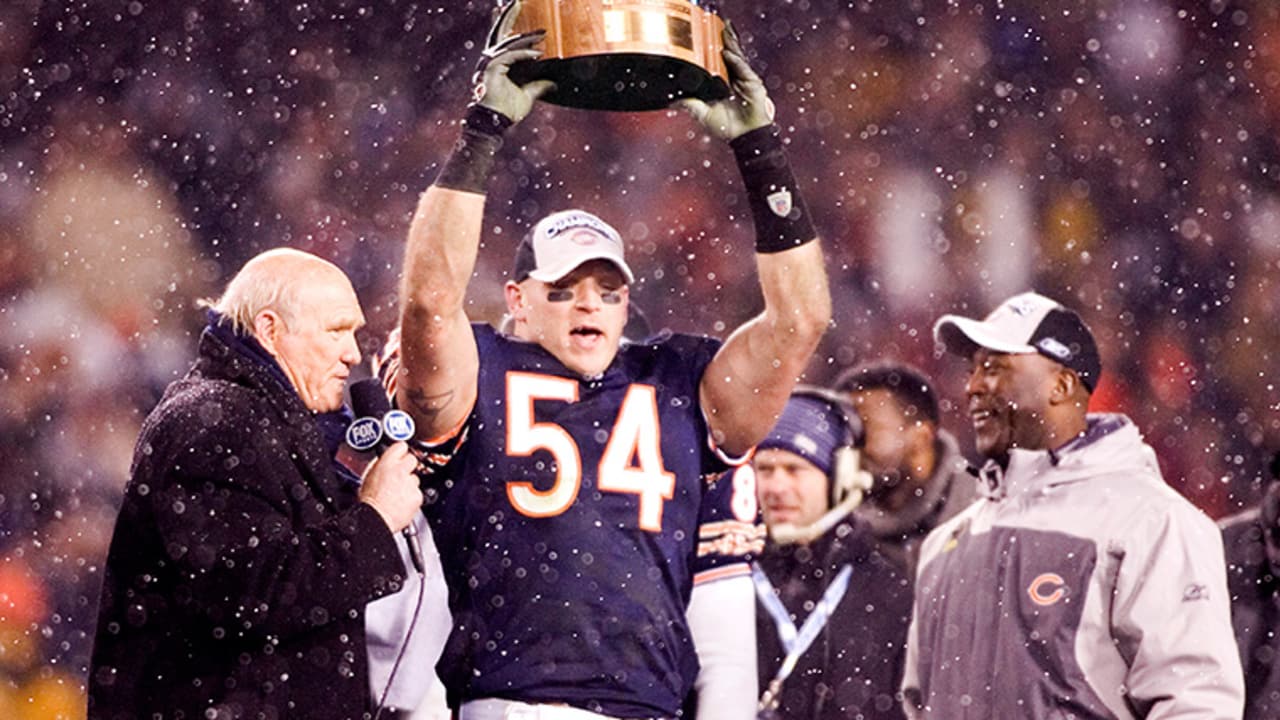 Chicago Bears' Brian Urlacher holds the NFC Championship Trophy as head  coach Lovie Smith looks on after beating the New Orleans Saints 39-14 in  the NFC Championship game at Soldier Field in