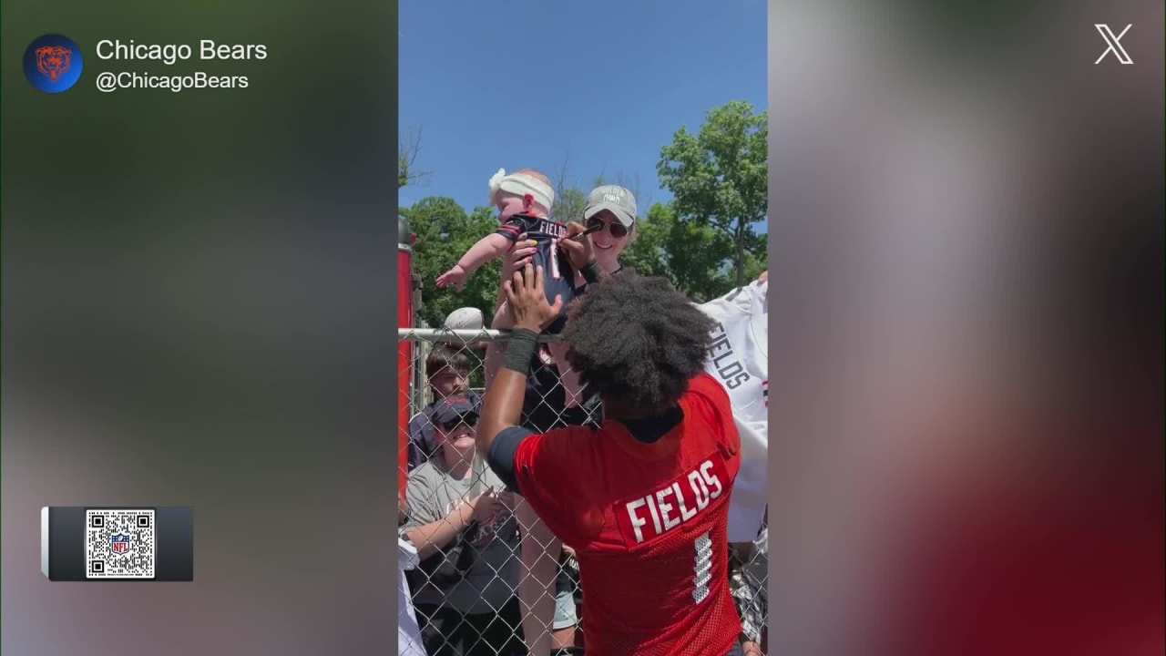 Chicago Bears quarterback Justin Fields signs baby's Bears jersey at  training camp