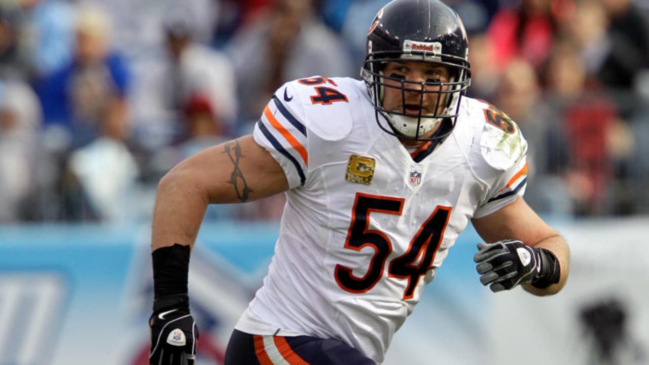 Former New Mexico and Chicago Bears football player Brian Urlacher applauds  on the field as his jersey number is retired during a halftime ceremony at  an NCAA college football game against Air