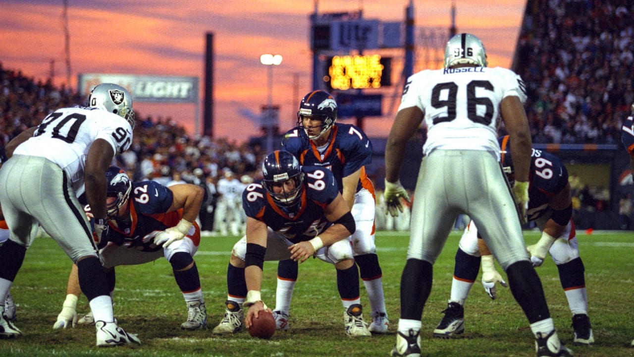 As Denver quarterback John Elway (7) watches, Broncos running back