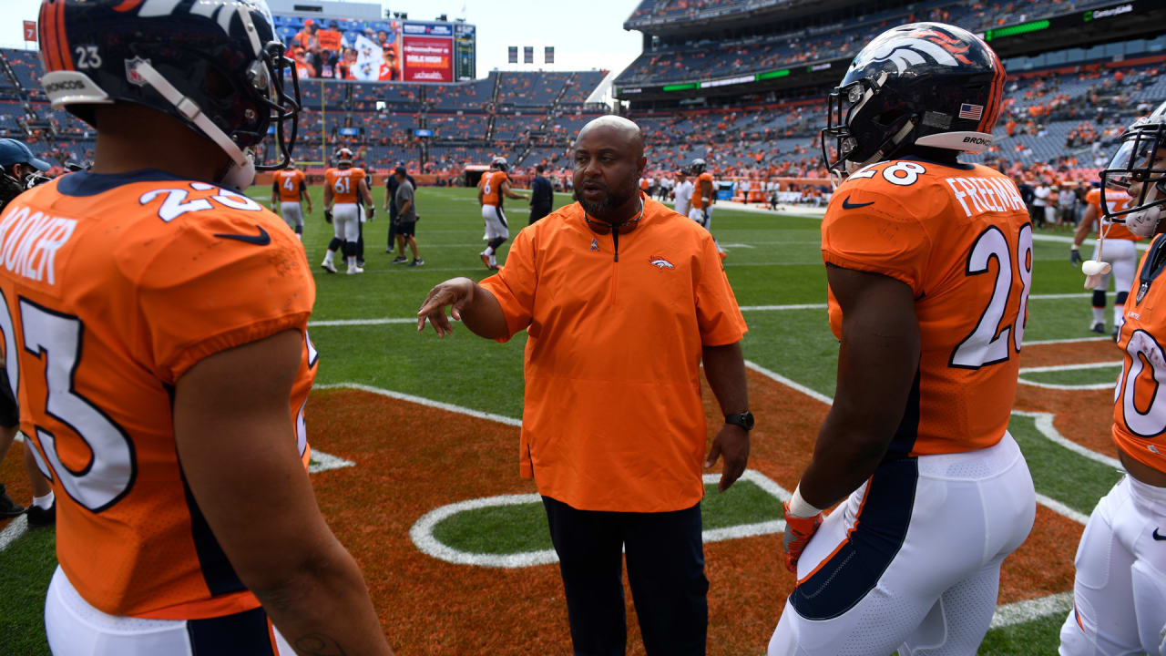 Denver Broncos running backs coach Curtis Modkins while taking