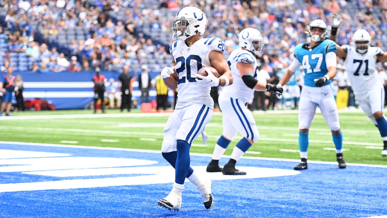 Indianapolis Colts running back Jordan Wilkins (20) runs through an opening  in the line during an NFL football game against the Carolina Panthers,  Sunday, Aug. 15, 2021, in Indianapolis. (AP Photo/Zach Bolinger