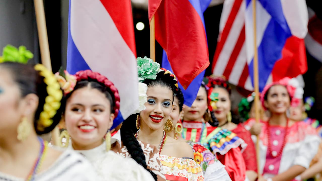 Dancers hold flags of nations of hispanic heritage honoring Hispanic  Heritage Month prior to a NFL