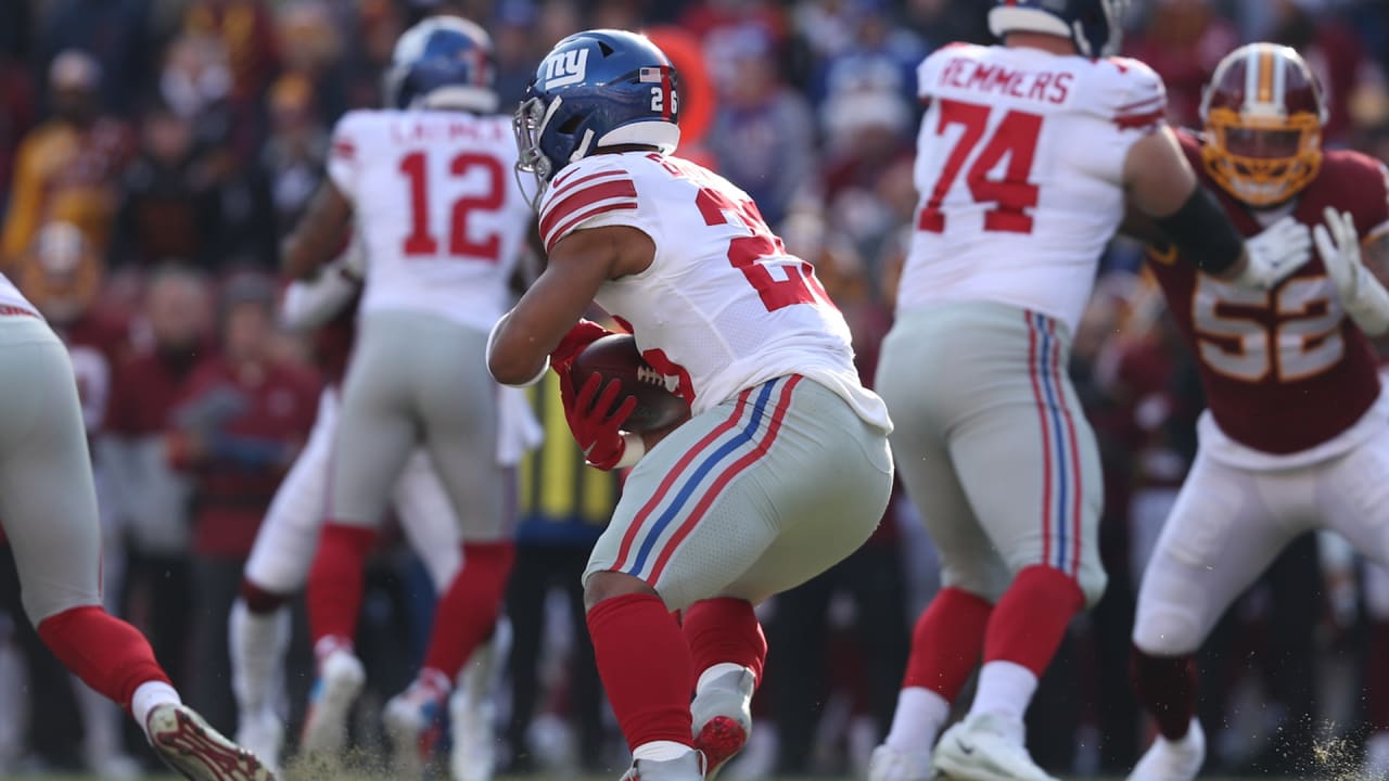 New York Giants players surround running back Saquon Barkley