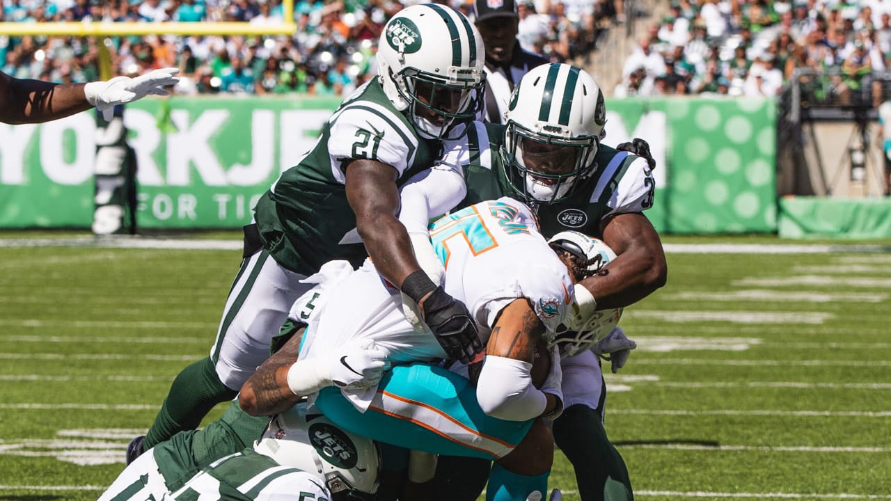 FILE - New York Jets Ronnie Lott (42) and Jeff Lageman, left, bring down Miami  Dolphins Mark Higgs (21) during the first half of an NFL football game in  Miami, Sept. 12