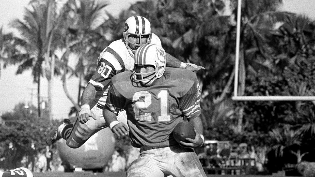 FILE - New York Jets Ronnie Lott (42) and Jeff Lageman, left, bring down  Miami Dolphins Mark Higgs (21) during the first half of an NFL football  game in Miami, Sept. 12