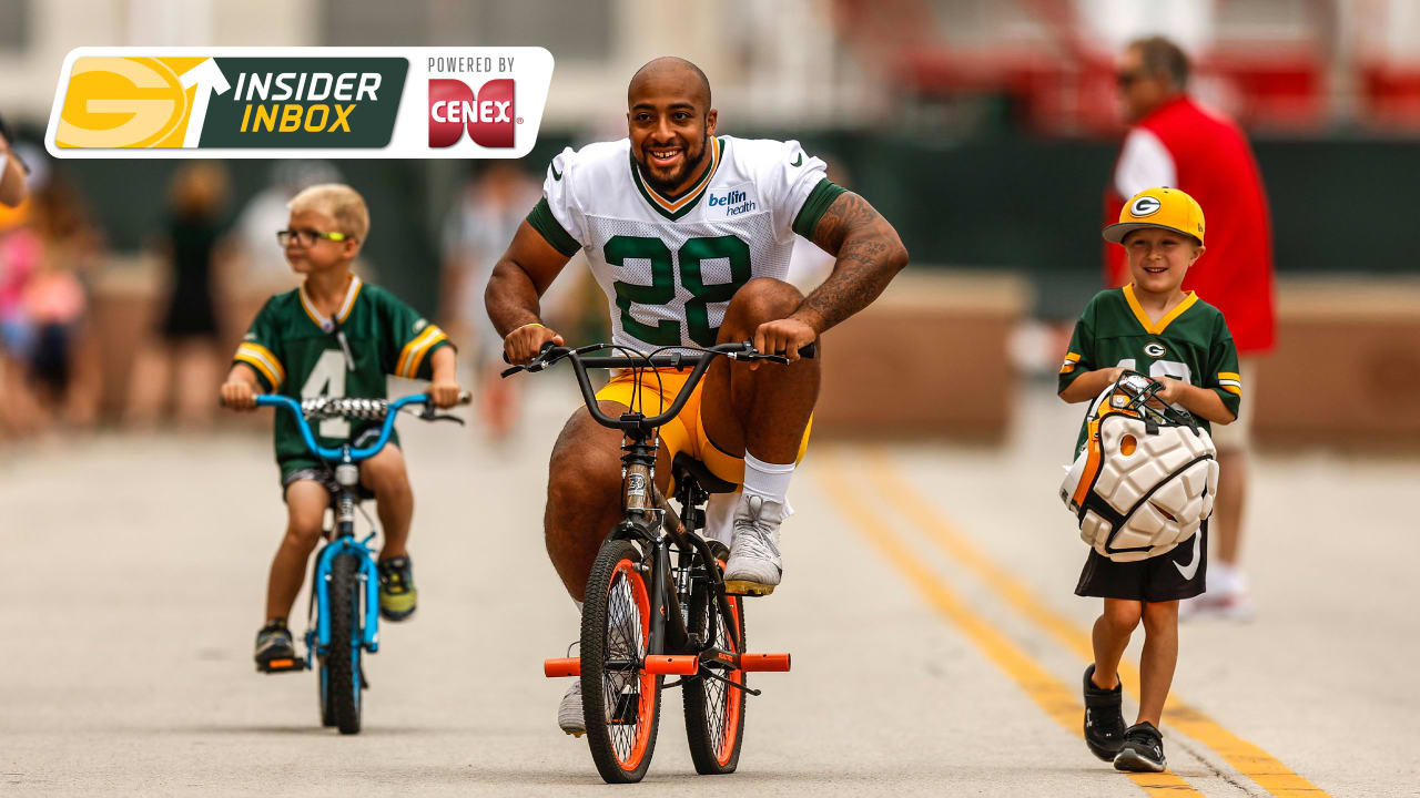 AJ Dillon of the Green Bay Packers rides a bike to training camp