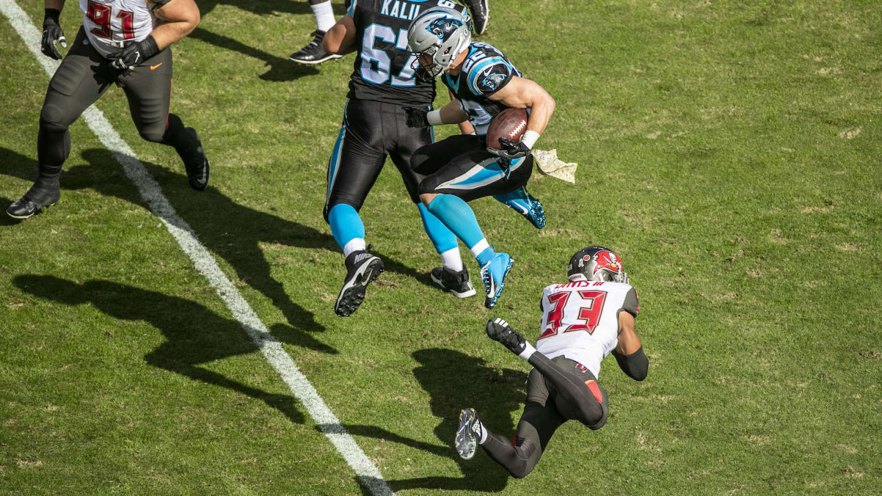 Christian McCaffrey of the Carolina Panthers jumps over Tre