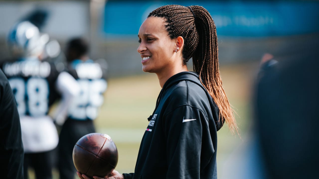 Stylish African American female coach, stands at whiteboard, in