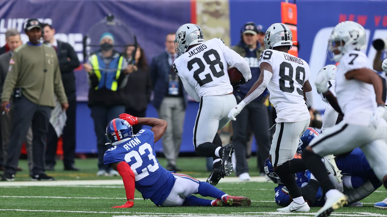 Las Vegas Raiders running back Josh Jacobs (28) stiff arms New York Giants  cornerback James Bra …