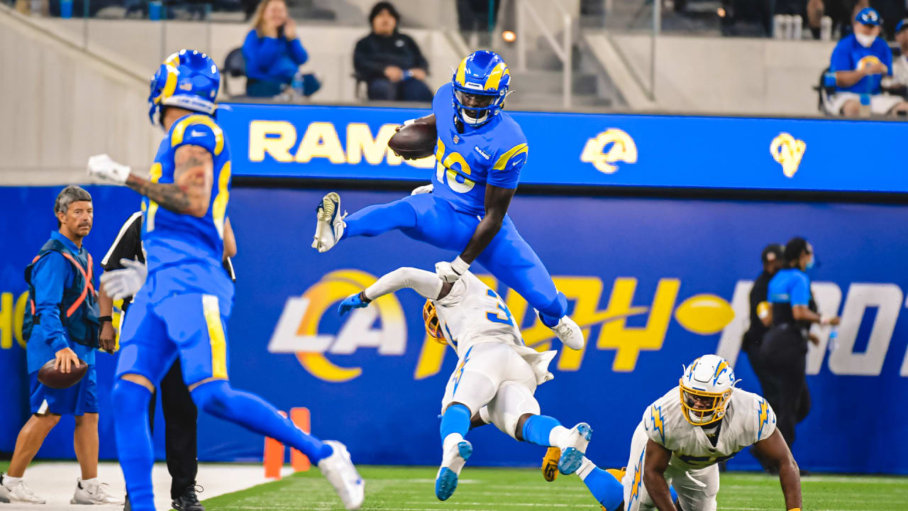 Los Angeles Rams quarterback Bryce Perkins (16), top, leaps over Los Angeles  Chargers defensive back Kemon