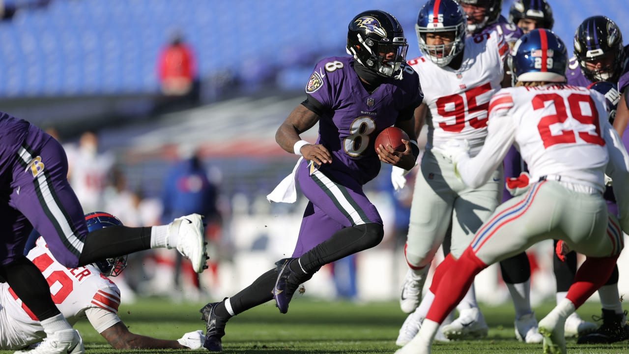 Baltimore Ravens quarterback Lamar Jackson charges past defenders deep in  New York Giants' territory