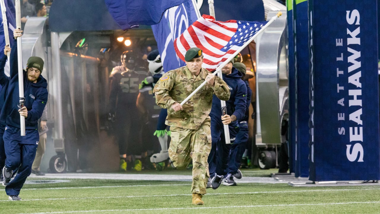 Military personnel carry the colors before the start of an NFL