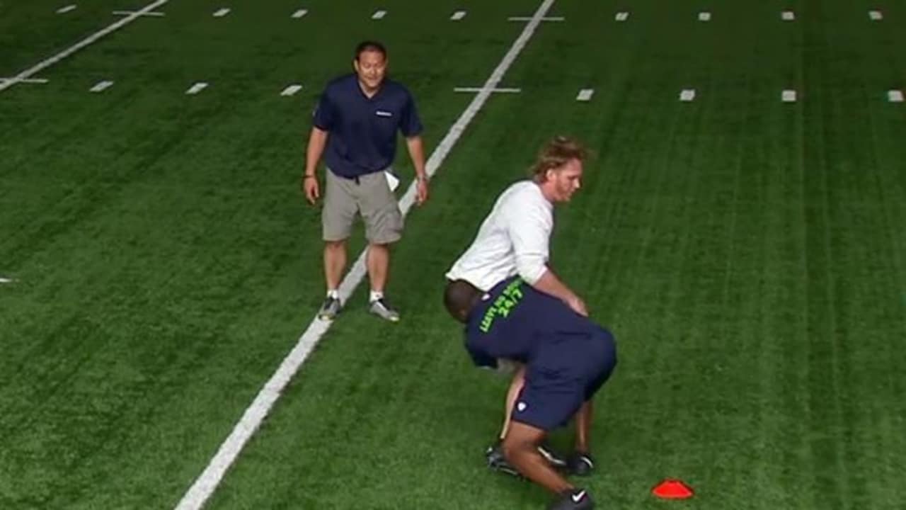 Seattle Seahawks defensive player tackling opponent
