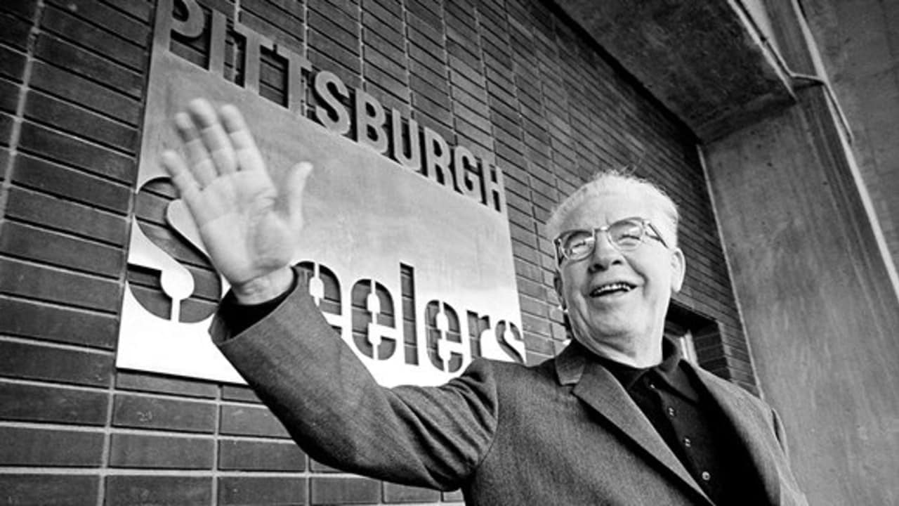 Team owner Art Rooney pauses with his cigar before a mural in the