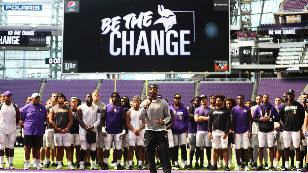 The words 'End Racism' are seen painted in an end zone during an NFL  football game