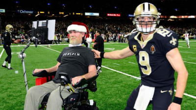 Former New Orleans Saints Steve Gleason, left, poses for a photo with  Saints owner Gayle Benson, right, Steve's children, Rivers, 11, Gray, 4,  and an unidentified member of Team Gleason, before an