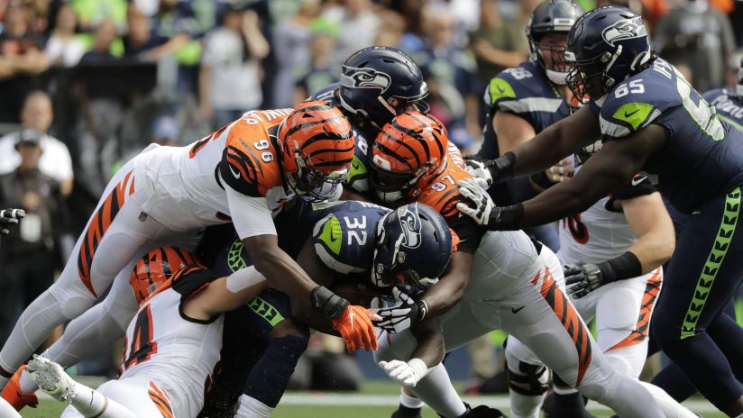 Seattle Seahawks running back Chris Carson (32) is tackled by Cincinnati Bengals' Carlos Dunlap (96) and Geno Atkins (97) during the first half of an NFL football game Sunday, Sept. 8, 2019, in Seattle. (AP Photo/John Froschauer)