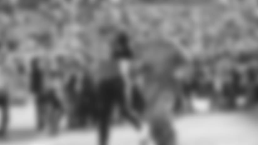 Andy Dalton runs out in the field with a member of the United States military in 2017.