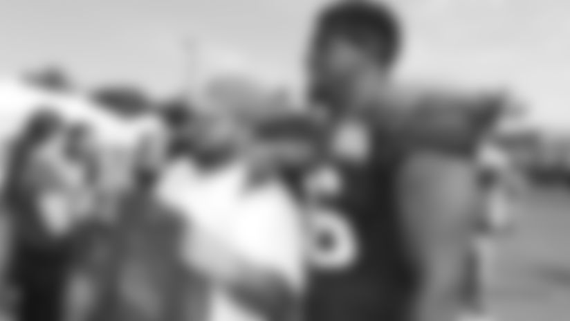 Reserve defensive lineman Mike Love takes a photo with a fan at training camp.