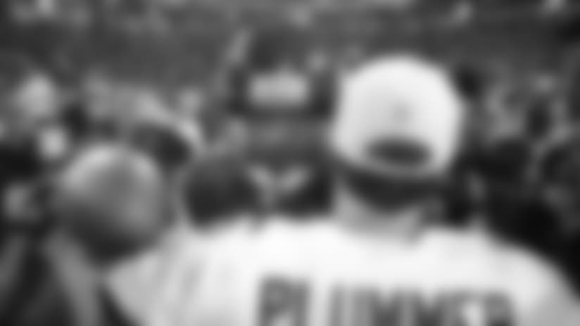 Arizona Cardinals quarterback Jake Plummer gives Minnesota Vikings quarterback Randall Cunningham a hug after the NFC divisional playoff game Sunday, Jan. 10, 1999, in Minneapolis. The Vikings won 41-21.