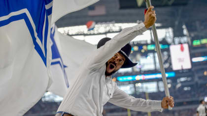 Flag-bearers in cowboy hats whip up enthusiasm in the crowd with a brisk  run with flags displaying the Dallas Cowboys' lone-star emblem at the  Cowboys' home field AT&T Stadium in Arlington, Texas