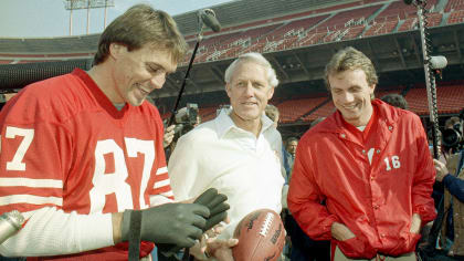 San Francisco 49ers QB Joe Montana kneeling with coach Bill Walsh