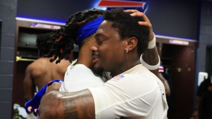 Buffalo Bills, from Left, Bill Brooks, Andre Reed, Mickey Washington, Bruce  Smith (looking away), Pete Metzelaars (standing), Carwell Gardner, and Nate  Odomes (reaching) celebrate in their Locker room with the Lamar Hunt