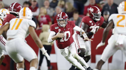 Alabama quarterback Mac Jones, right, holds a team jersey with NFL  Commissioner Roger Goodell a …