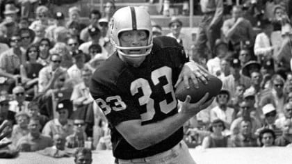 Oakland Raiders tight end Dave Casper, left, carries the ball