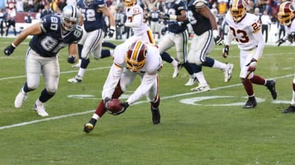 Groundskeepers pull the protective trap off of the field after a rainstorm  before an NFL football game between the Dallas Cowboys and Washington  Redskins in Landover, Md., on Sunday, Sept.. 12, 2010. (