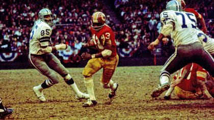 Dallas Cowboys quarterback Roger Staubach (12) looks for a receiver during  the NFC Championship game against the Washington Redskins at RFK Stadium in  Washington, DC on December 31, 1972. Blocking for Staubach