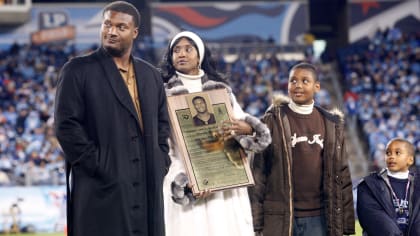 Former Tennessee Titans running back Eddie George, second from left, stands  with family members of the late Titans quarterback Steve McNair, as the  numbers for George and McNair are retired during halftime