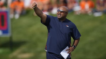 Denver Broncos running backs coach Curtis Modkins while taking