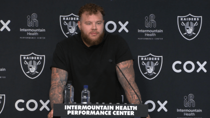 Las Vegas Raiders center Andre James walks with trainers after an