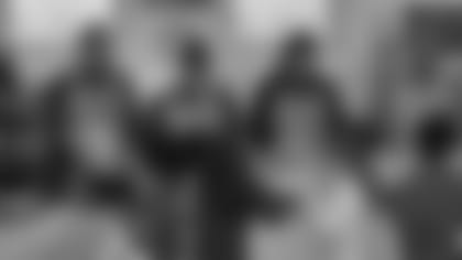 Bills coaches Heath Farwell (left), Matthew Smiley, John Butler and Jim Salgado serve lunches to students at St. Luke's Mission of Mercy on Feb. 7.