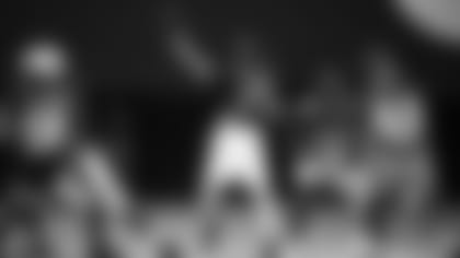 QB Kyler Murray throws a pass with defensive backs Budda Baker (3) and Byron Murphy (7) defending during training camp.