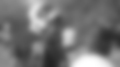 Running back David Johnson laughs with running backs coach Kirby Wilson during some downtime at Monday's initial on-field work for early training camp. Quarterbacks, rookies and players coming off injury reported Sunday; the full team reports Friday.