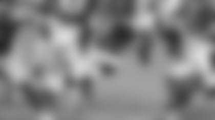 Running back Chase Edmonds busts through the line at a training camp practice.