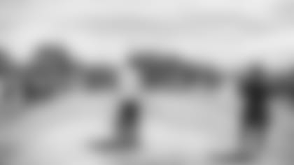 Coach Kliff Kingsbury and head athletic trainer Tom Reed (right) talk with the team after a minicamp practice.