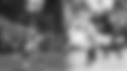 At left, safety Robert Griffith runs out with the Mexican flag before the Cardinals' game in Mexico City in 2005 against the 49ers; at right, linebacker Isaiah Simmons moves up to make a play against the 49ers in 2021.