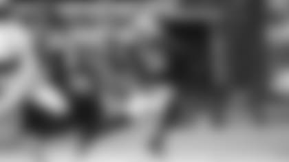 Safety Budda Baker returns an interception against Seattle, hoping to stiff-arm pursuer DK Metcalf.